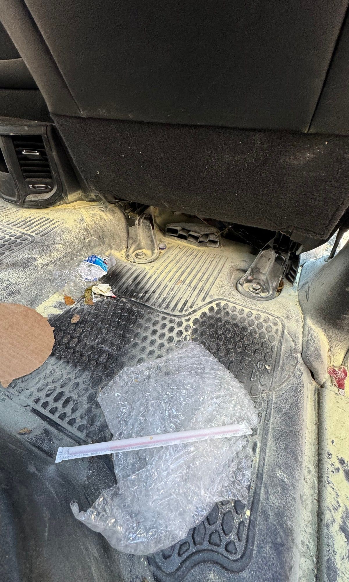 Before: truck rear floor covered in dirt, trash and packing material